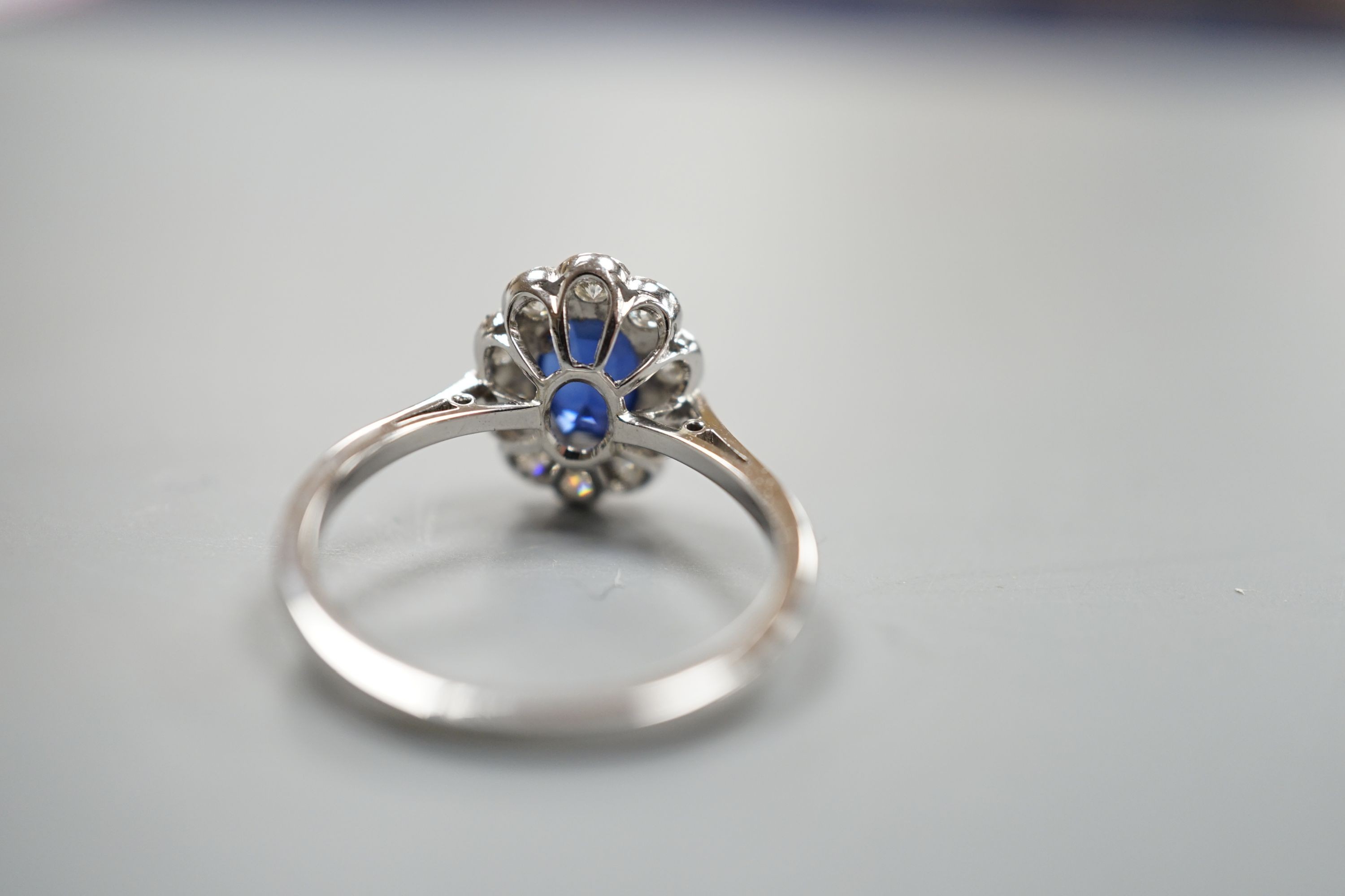 An 18ct and plat. sapphire and diamond set oval cluster ring, size N, gross weight 2.9 grams.
